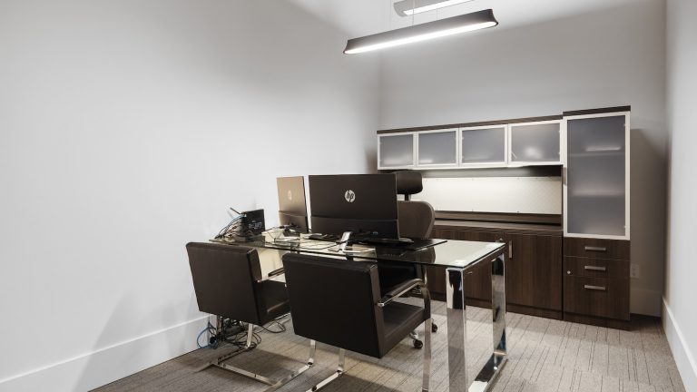 a room with a desk and chairs